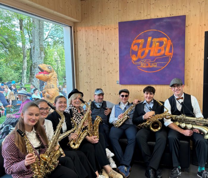 Bild des Saxofon-ensembles Saxmaniacs beim Kinder- und Familienfest 2024, sitzne versammelt mit ihren Instrumenten auf der Couch